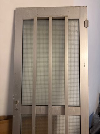 Puerta metálica con reja y cristal