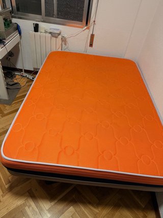 Cama con colchón naranja y azul