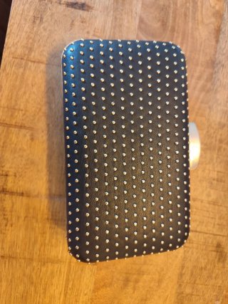 Bolso de mano negro con tachuelas doradas