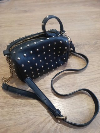 Bolso negro con tachuelas doradas