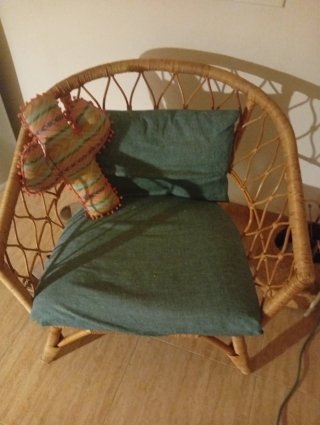 Sillón de mimbre con cojín verde