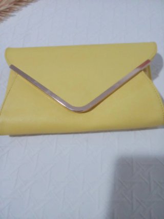 Bolso de mano amarillo con detalle metálico