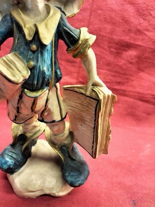 Estatueta vintage rapaz com chapéu e livros