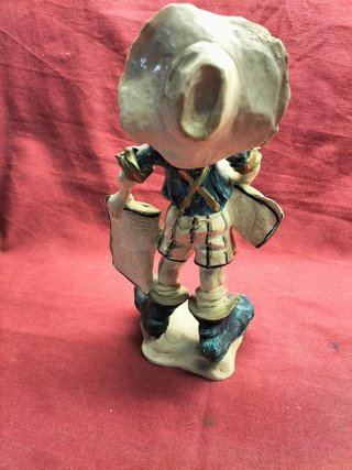 Estatueta vintage rapaz com chapéu e livros