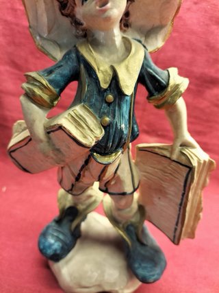 Estatueta vintage rapaz com chapéu e livros
