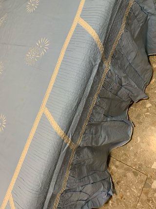 Ropa de cama azul con bordado blanco