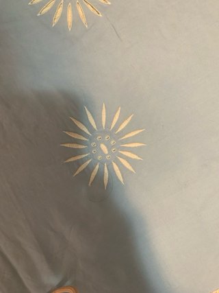 Ropa de cama azul con bordado blanco