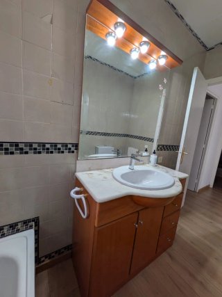 Mueble de baño madera y mármol con espejo tocador.