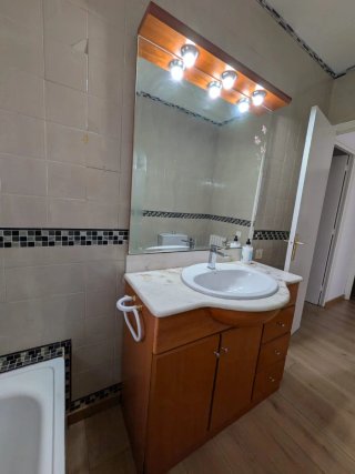 Mueble de baño madera y mármol con espejo tocador.