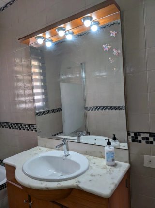 Mueble de baño madera y mármol con espejo tocador.