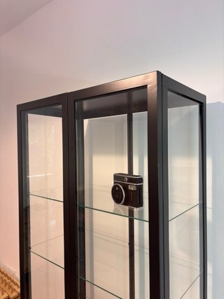 Vitrina alta negra con puertas de cristal