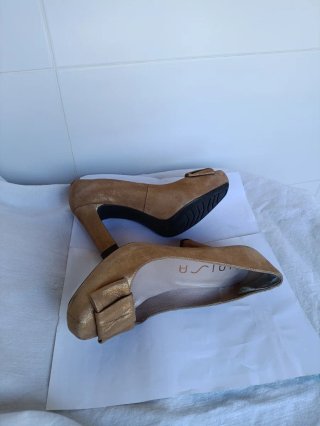 Zapatos de tacón dorados con lazo