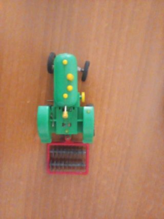 Tractor de juguete verde a cuerda con complementos