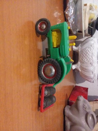 Tractor de juguete verde a cuerda con complementos