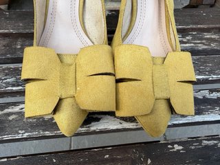 Zapatos de tacón amarillos con lazo