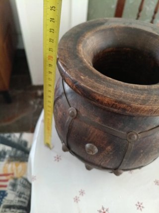 Jarrón de madera oscuro con detalles metálicos.