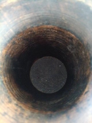 Jarrón de madera oscuro con detalles metálicos.