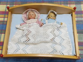 Cama de juguete con 2 muñecas