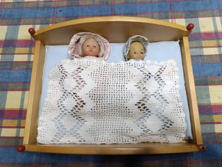 Cama de juguete con 2 muñecas