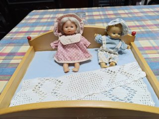 Cama de juguete con 2 muñecas