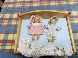 Cama de juguete con 2 muñecas