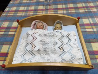 Cama de juguete con 2 muñecas