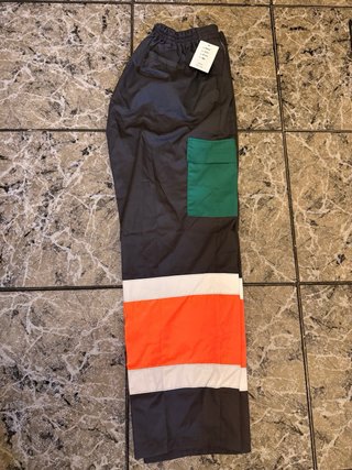 Pantalones grises con detalles naranjas
