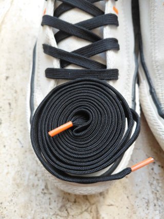 Converse beige con detalles naranjas y negros.