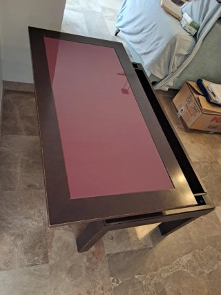 Mesa de centro elevable de madera y cristal.