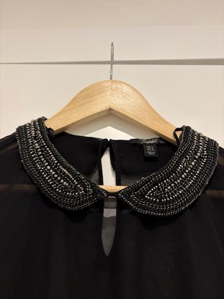 Blusa negra transparente con cuello pedrería
