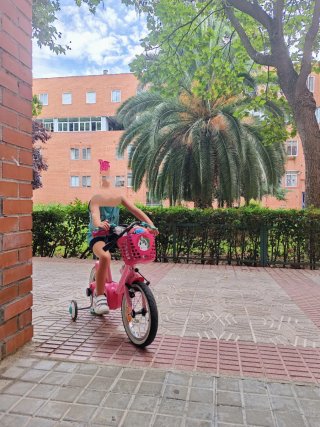 Bicicleta infantil rosa con ruedines y cesta