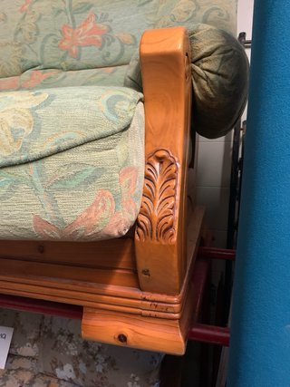 Sofá verde con estructura de madera