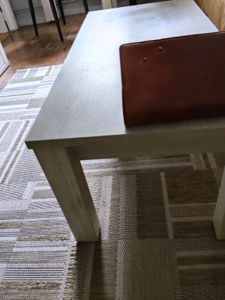 Mesa de centro de madera blanca, veteada en gris.