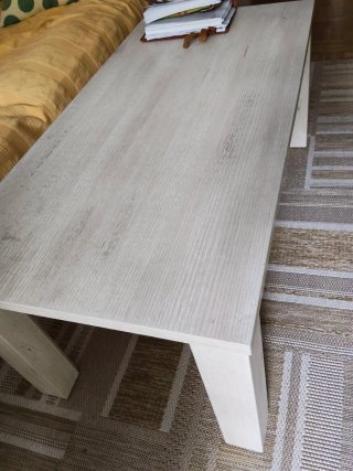 Mesa de centro de madera blanca, veteada en gris.