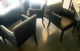 Butacas de piel negras con patas de madera