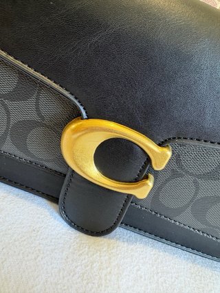 Mala Coach preta com detalhe dourado
