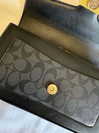 Mala Coach preta com detalhe dourado