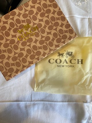 Mala Coach preta com detalhe dourado