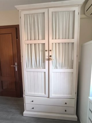 Armario blanco con puertas de cristal y cajones