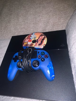 Consola PS4 con mando azul y juego GTA V