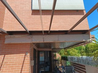 Pérgola aluminio marrón con toldo beige