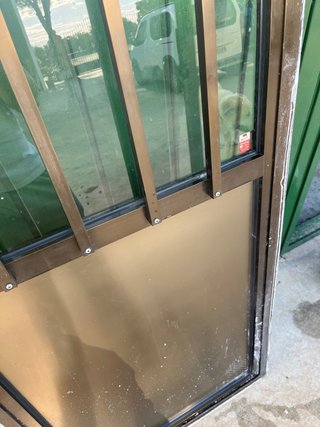 Puerta aluminio con rejas y cristal