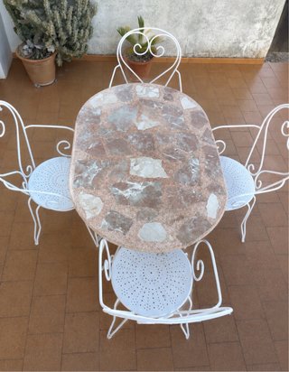 Mesa con base de piedra y 4 sillas hierro forjado