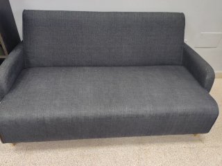 Sofá de tela gris con patas de madera