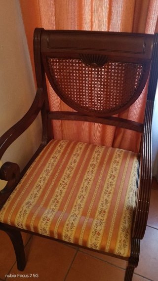 Sillón antiguo de madera con asiento de tela