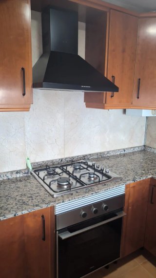 Cocina completa madera y encimera granito.