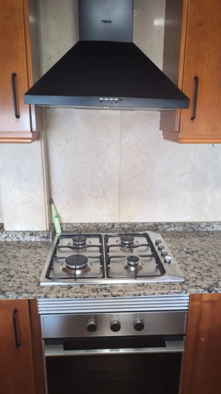 Cocina completa madera y encimera granito.