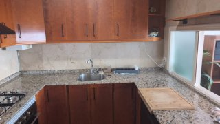 Cocina completa madera y encimera granito.