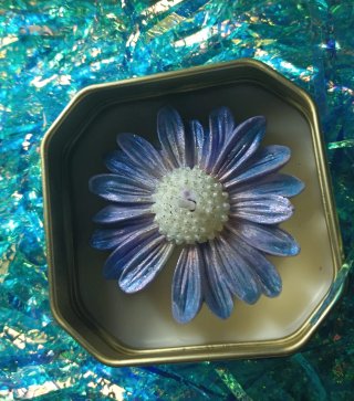 Caja metálica azul decorada con sellos y flores