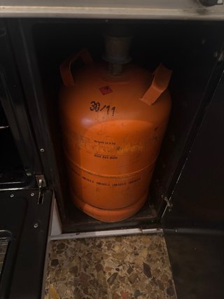 Cocina de gas blanca con horno y porta bombonas